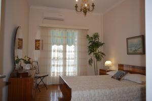 a bedroom with a large bed and a window at ELENI'S NEOCLASSICAL HOME in Athens