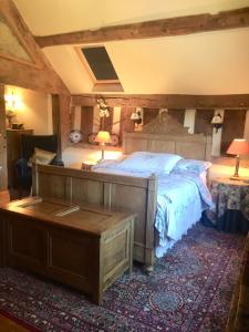 a bedroom with a bed and a table and two lamps at Lower House Farm B&B, Herefordshire in Hergest