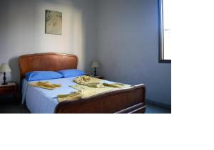 um quarto com uma cama com uma cabeceira de madeira em Hotel Sorrento em Belo Horizonte
