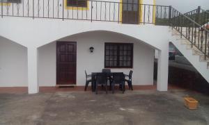 een zwarte tafel en stoelen op een binnenplaats met een trap bij Casa da Sogra - Apartamento 3 in Faja Grande