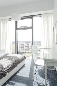 1 dormitorio con cama, mesa y escritorio en Platinum Sky en Wroclaw