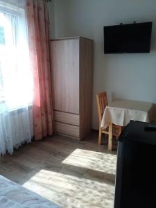 a room with a bedroom with a table and a window at Baranówka in Muszyna