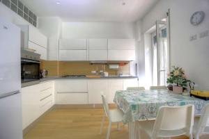 a kitchen with a table and white cabinets and a table and chairs at Holiday aRoma in Rome