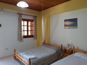 a bedroom with two beds and a window at Koutadelias rooms in Kálamos