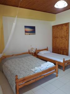 two twin beds in a room with at Koutadelias rooms in Kalamos