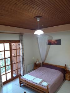 sypialnia z łóżkiem i drewnianym sufitem w obiekcie Koutadelias rooms w mieście Kalamos
