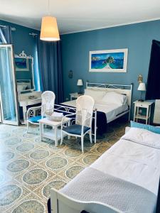 タオルミーナにあるB&B A Due Passi Dal Mareのベッドルーム1室(ベッド2台、椅子2脚、テーブル付)