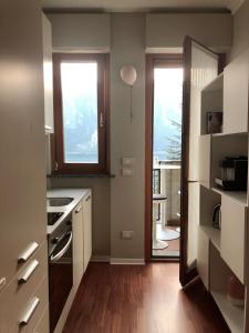una cucina con banconi bianchi e 2 finestre di appartamento con bellissima vista a Campione dʼItalia