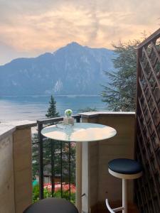 a table and stool on a balcony with a view of the ocean at Suite LAGO e relax in Campione dʼItalia
