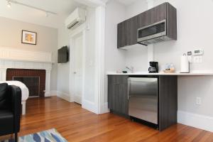 uma cozinha com um frigorífico de aço inoxidável e um micro-ondas em Large Studio w/ Queen AND Sofa Bed..#38 em Brookline