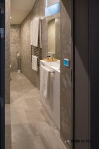 Un baño con lavabo y tocador con toallas. en Burgo da Villa, en Castelo de Vide