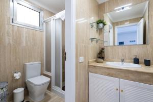a bathroom with a toilet and a sink and a mirror at Amarre Ocean in Puerto de Mogán +64 photos