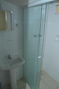 uma casa de banho com um lavatório e uma cabina de duche em vidro. em Pousada Santo Antônio em Piraí