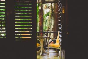 a table and a chair in a room with plants at Cocos Cabañas Playa del Carmen Adults Only in Playa del Carmen