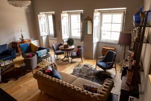 Una sala de estar con un sofá y algunas sillas. en Burgo da Villa, en Castelo de Vide