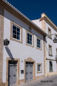 a white building with two doors on a street at Burgo da Villa in Castelo de Vide