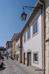 uma rua com edifícios brancos e uma luz de rua em Burgo da Villa em Castelo de Vide