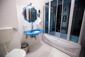 a bathroom with a blue sink and a shower at Hotel Bliss in Bucharest