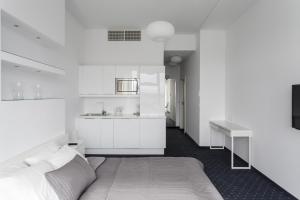een witte slaapkamer met een bed en een wastafel bij Platinum Sky in Wrocław