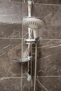 a shower head in a bathroom with a tile wall at Corner Garden Hotel in Istanbul