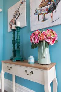 une table avec un vase de fleurs sur elle dans l'établissement Aqua On Reed, à Oamaru