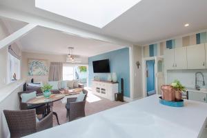 a kitchen and living room with a table and chairs at Aqua On Reed in Oamaru
