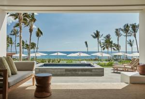 een woonkamer met een zwembad en palmbomen bij Four Seasons Resort Oahu at Ko Olina in Kapolei