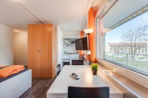 a room with a desk and a large window at Anstatthotel Zug - self-check-in in Zug