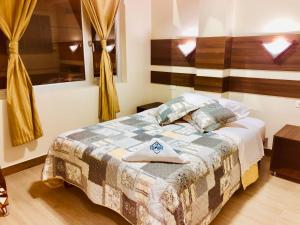1 dormitorio con 1 cama con edredón en Hotel La Cumbre, en Baños