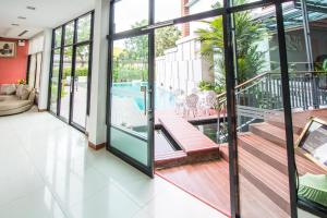 a house with a balcony with a swimming pool at Mamaison Hotel in Buriram