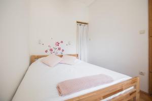 Una cama con sábanas blancas y toallas rosas. en Apartment Atlas, en Zagreb