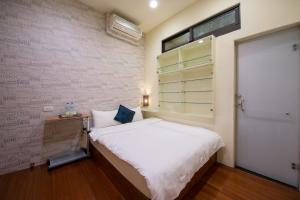 ein kleines Schlafzimmer mit einem Bett und einem Fenster in der Unterkunft Albert B&B in Luodong