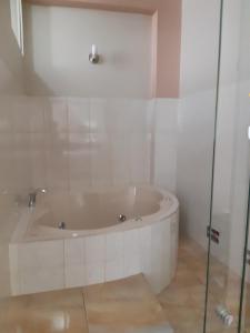 a bath tub in a bathroom with a glass door at Hotel El Ensueño in Tingo María
