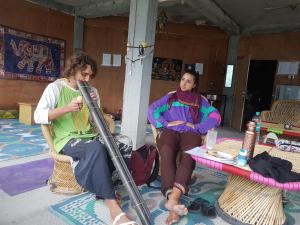 Dos mujeres sentadas en sillas en una habitación en Sunface Homestay, en Manali