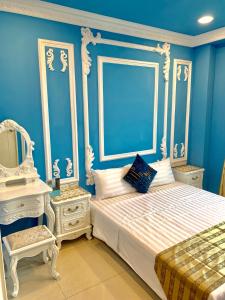 a blue bedroom with a bed and a mirror at Kinmen Happiness Shop in Jinning