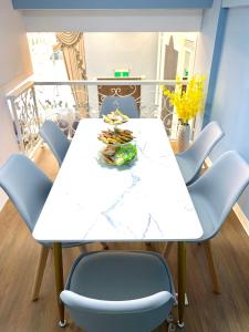 una mesa de comedor blanca con sillas azules en Kinmen Happiness Shop, en Jinning