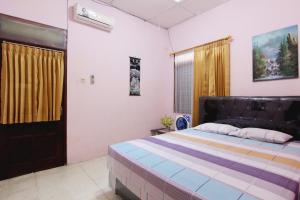 Tempat tidur dalam kamar di Batik Trinidar Homestay