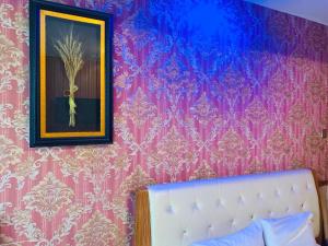 Un dormitorio con una pared púrpura con una foto y una cama en Horeka Hotel en Ulán Bator