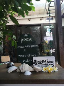 a sign on a table with flowers on it at Gili Nyepi in Gili Trawangan