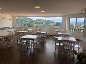 - une salle à manger avec des tables, des chaises et des fenêtres dans l'établissement Refúgio das Rosas, à Campos do Jordão