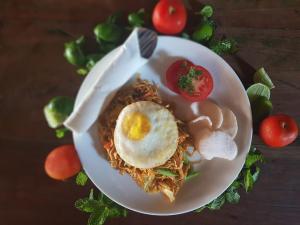 einen Teller Essen mit einem Ei auf Spaghetti in der Unterkunft Sama Sama Bungalows in Gili Trawangan