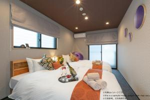 a bedroom with two beds with towels on them at Stay SAKURA Kyoto Kiyomizu Gojo in Kyoto
