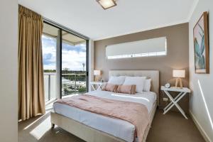 a hotel room with a large bed and a large window at Horton Apartments in Maroochydore