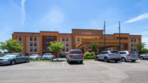a building with cars parked in a parking lot at Best Western Plus Fresno Airport Hotel in Fresno