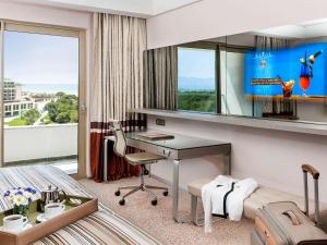 a hotel room with a desk and a window at Rixos Premium Belek - The Land of Legends Access in Belek