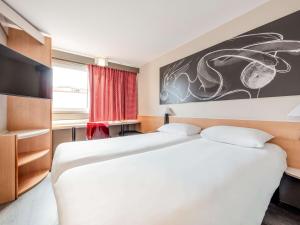 ein Schlafzimmer mit 2 Betten und einem Wandgemälde in der Unterkunft ibis Lille Roubaix Centre Grand-Place in Roubaix