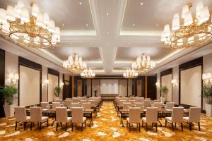 uma sala de conferências com mesas, cadeiras e lustres em Wyndham Grand Xi'an Residence em Xi'an