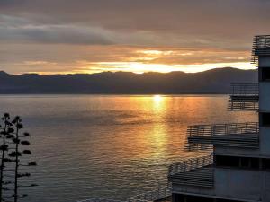 un tramonto su un corpo d'acqua con un edificio di Mercure Quemado Al-Hoceima Resort ad Al-Ḥoseyma