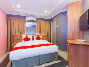 a bedroom with a large bed and a flat screen tv at OYO 746 Hotel Comfort in Ipoh