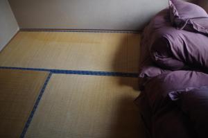 Rúm í herbergi á Kusatsu Onsen Guesthouse Gyoten